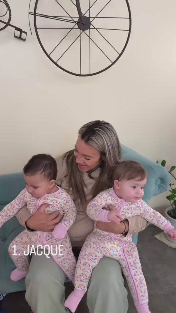 Two children being held, wearing Pastel Rainbows Zippies