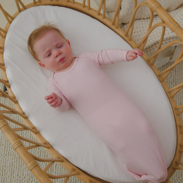 Baby in a crib wearing the Prima Pink Ribbed Infant Gown