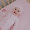 Newborn laying on the Prima Pink Fitted Mini Crib Sheet