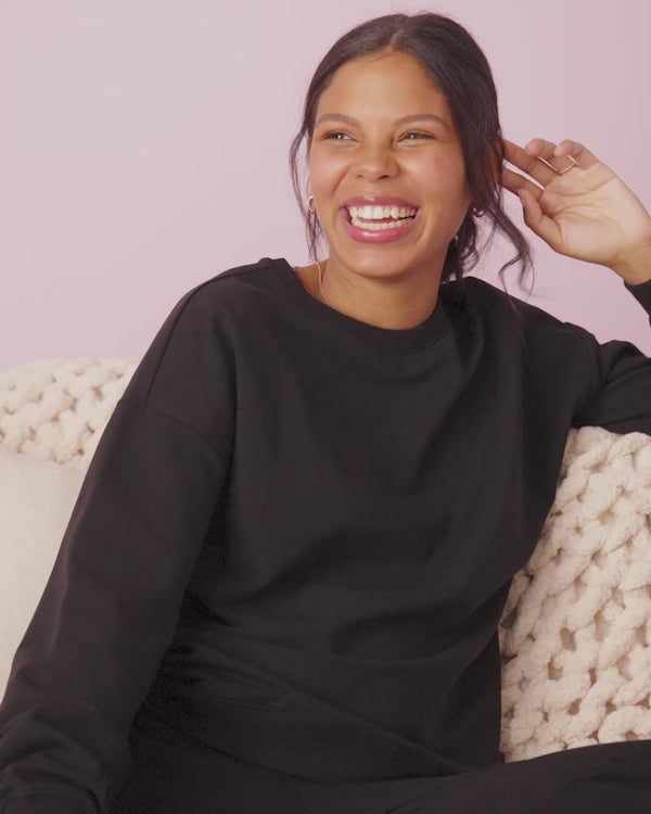 Woman wearing the Black Women's Everyday Crewneck Sweatshirt and Jogger on a blush back drop