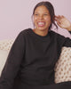 Woman wearing the Black Women's Everyday Crewneck Sweatshirt and Jogger on a blush back drop