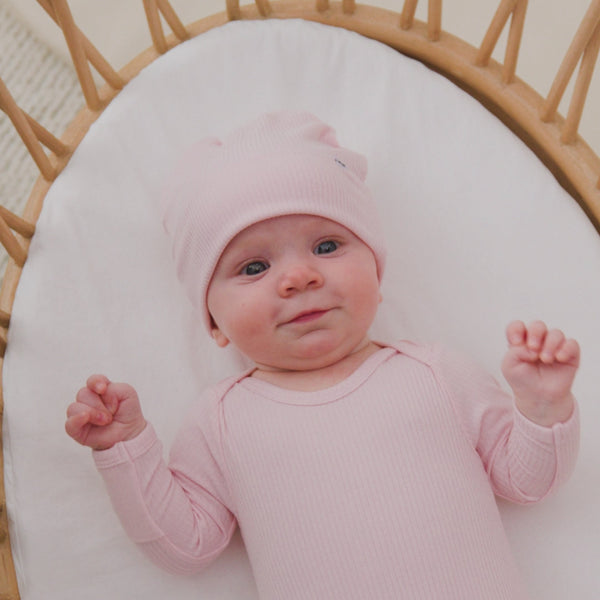 Baby in a crib wearing the Prima Pink Ribbed Infant Beanie