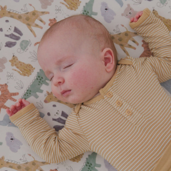 Baby wearing the Hazel Wood Stripe Henley Bodysuit on the sweet safari blanket