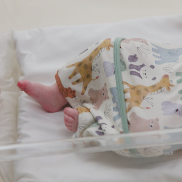 Parent folding over the envelope closure of a Sweet Safari Infant Gown