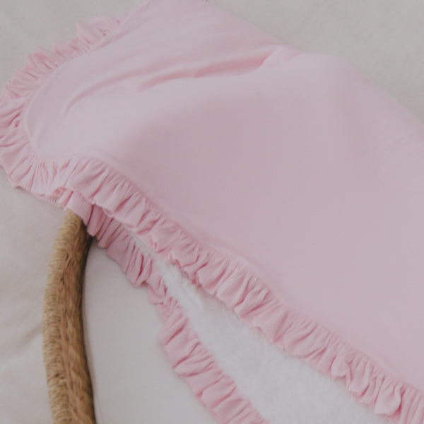 Baby laying on the Prima Pink Ribbed Ruffle Mini Cloud Blanket wearing a floral newborn outfit