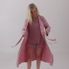 Woman putting on the Rosewood Women's Robe