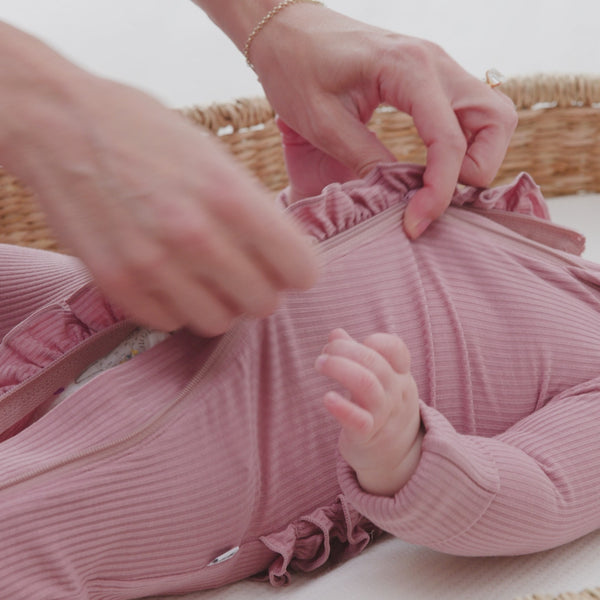 Parent zipping up the double zipper on a Rosewood Ruffle Zippy