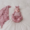 Newborn laying on bed wearing he Rosewood Fold-Over Legging with a matching striped bodysuit