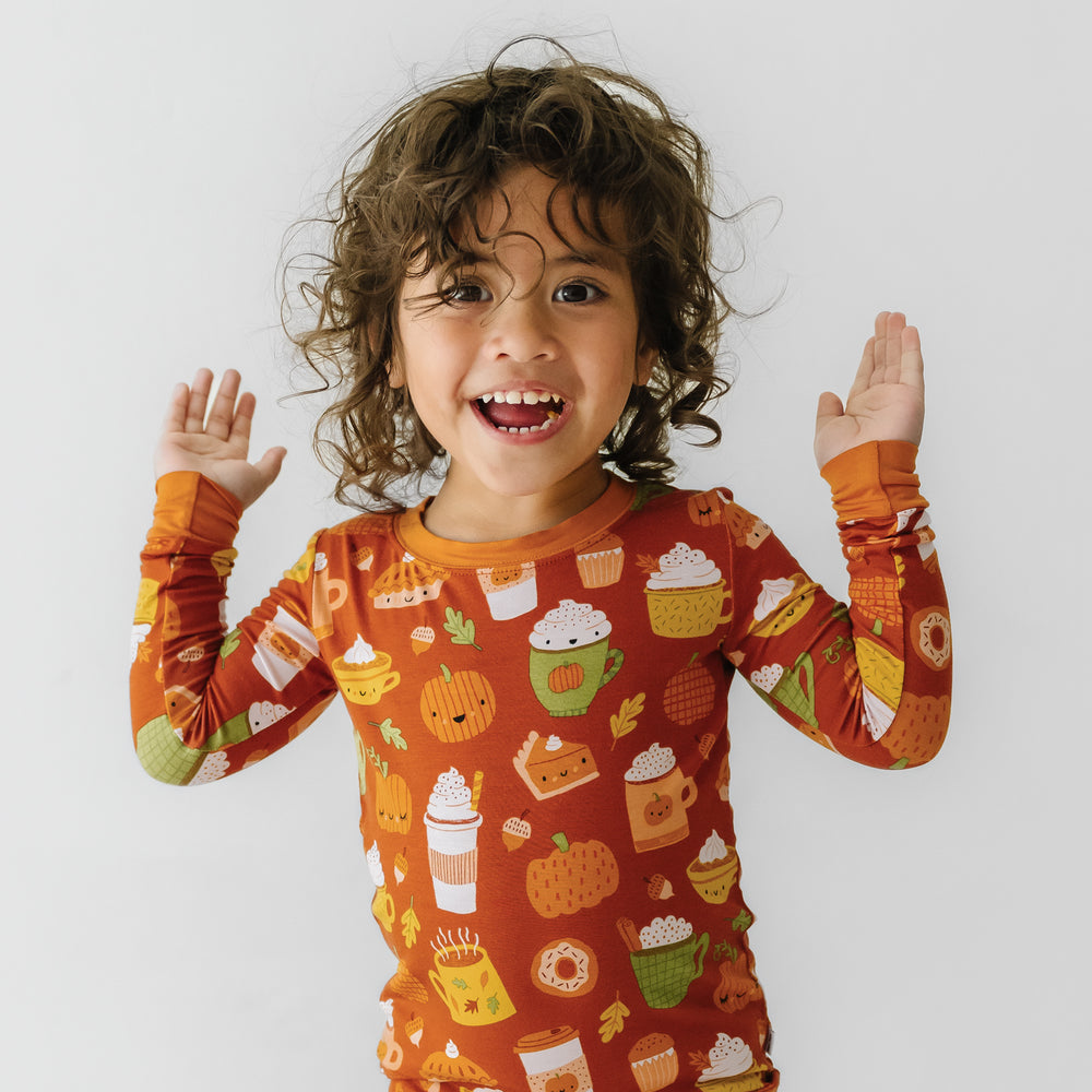 Close up image of a child wearing a Pumpkin Spice two-piece pajama set