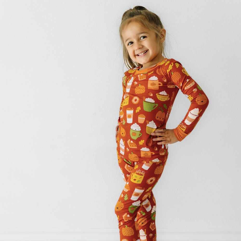 Child standing with their hands on their hips wearing a Pumpkin Spice two-piece pajama set