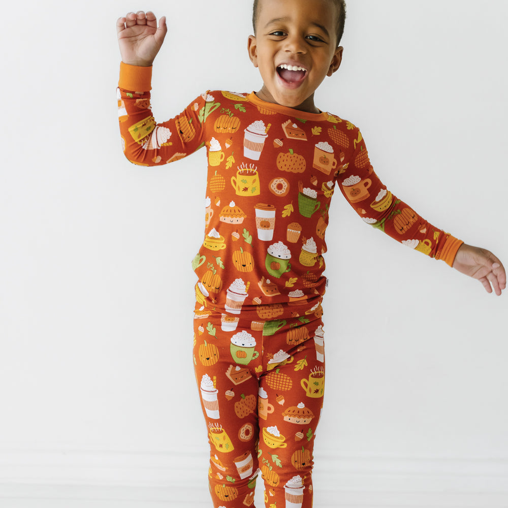 Child jumping wearing a Pumpkin Spice two-piece pajama set