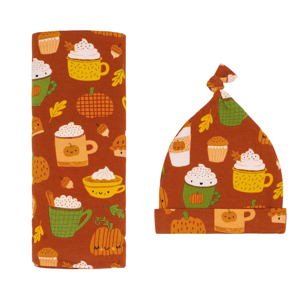 Flat lay image of a Pumpkin Spice swaddle and hat set