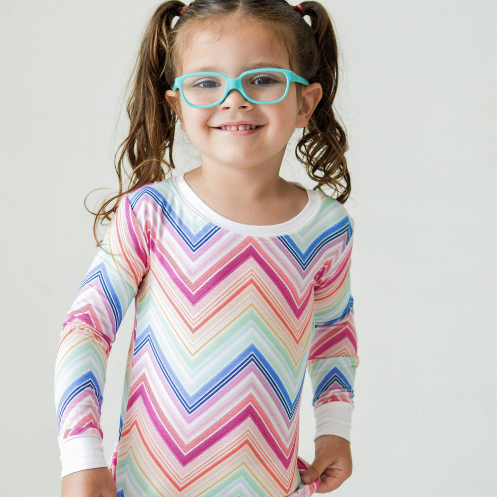 Close up image of a child wearing a Rainbow Chevron printed long sleeve pajama set
