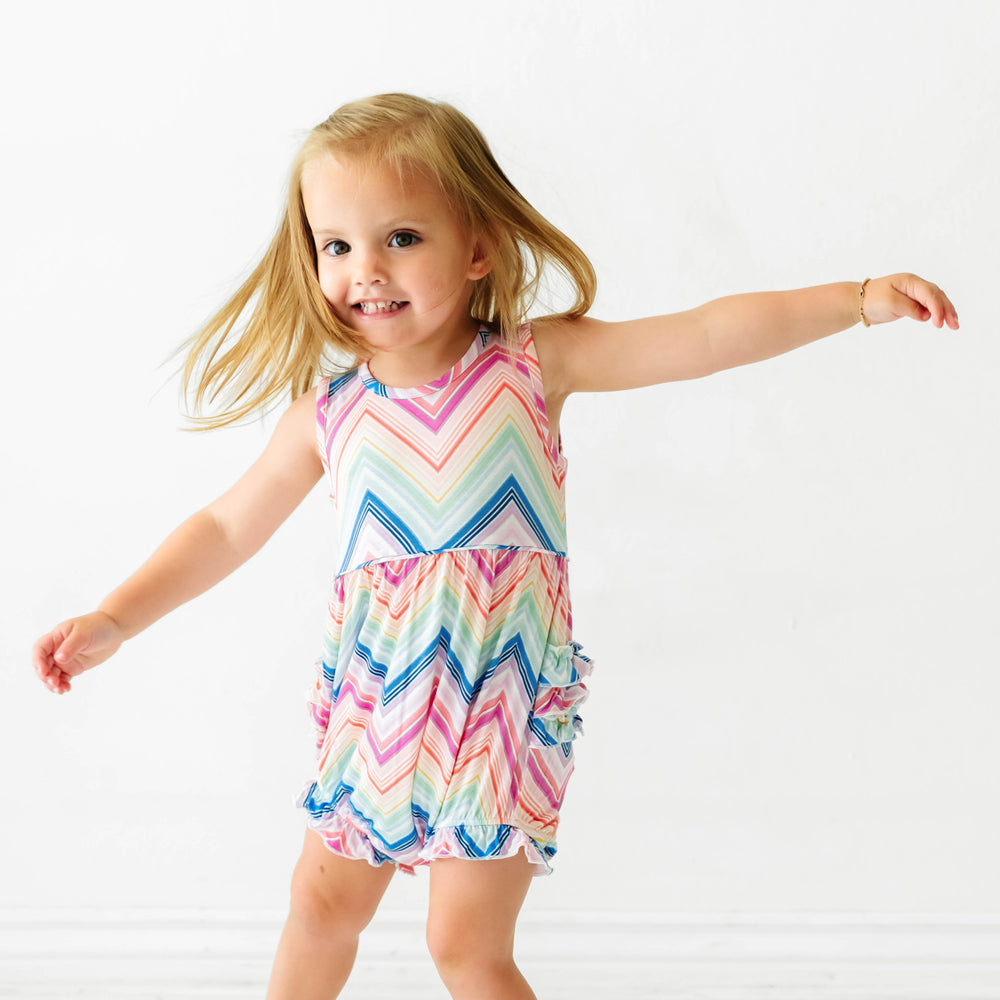 Alternate image of a child jumping wearing a Rainbow Chevron printed bubble romper