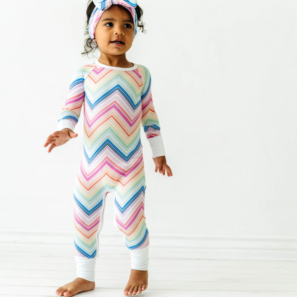 Alternate image of a child wearing a Rainbow Chevron printed crescent zippy