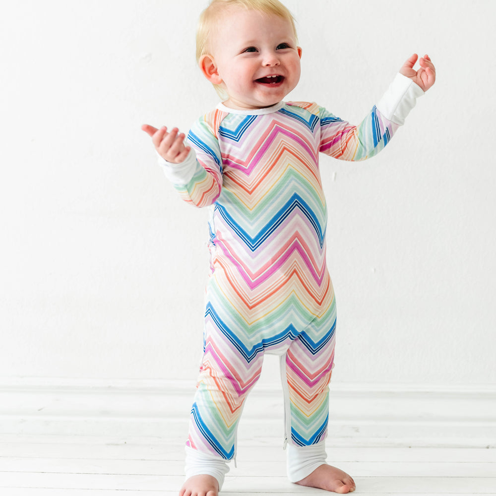 Click to see full screen - Child wearing a Rainbow Chevron printed crescent zippy