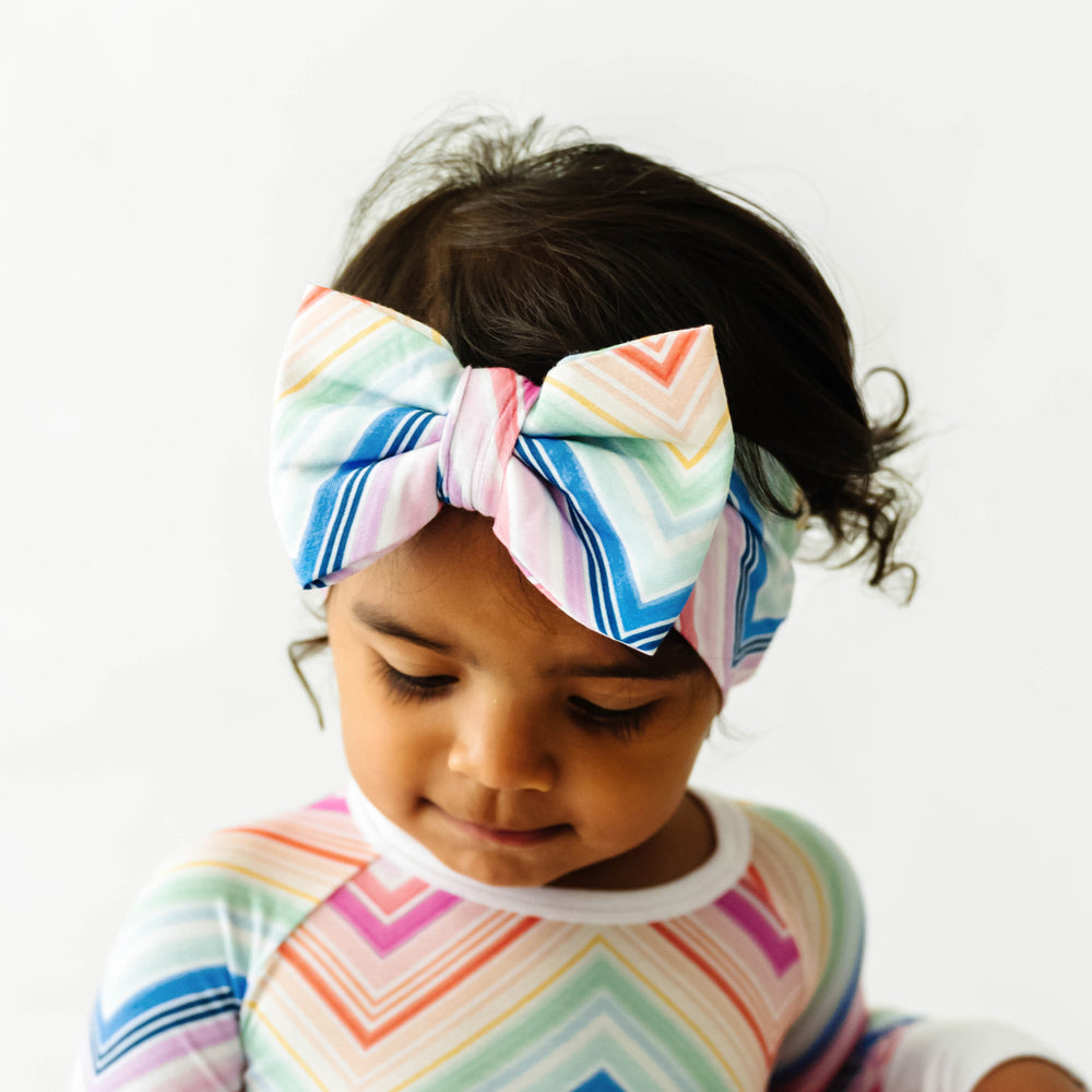 Child wearing a Rainbow Chevron printed luxe bow headband