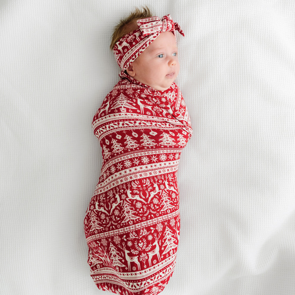 Alternate image of a child swaddled on a bed in a Reindeer Cheer swaddle and headband set
