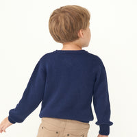 Back view image of a child wearing a Classic Navy knit sweater