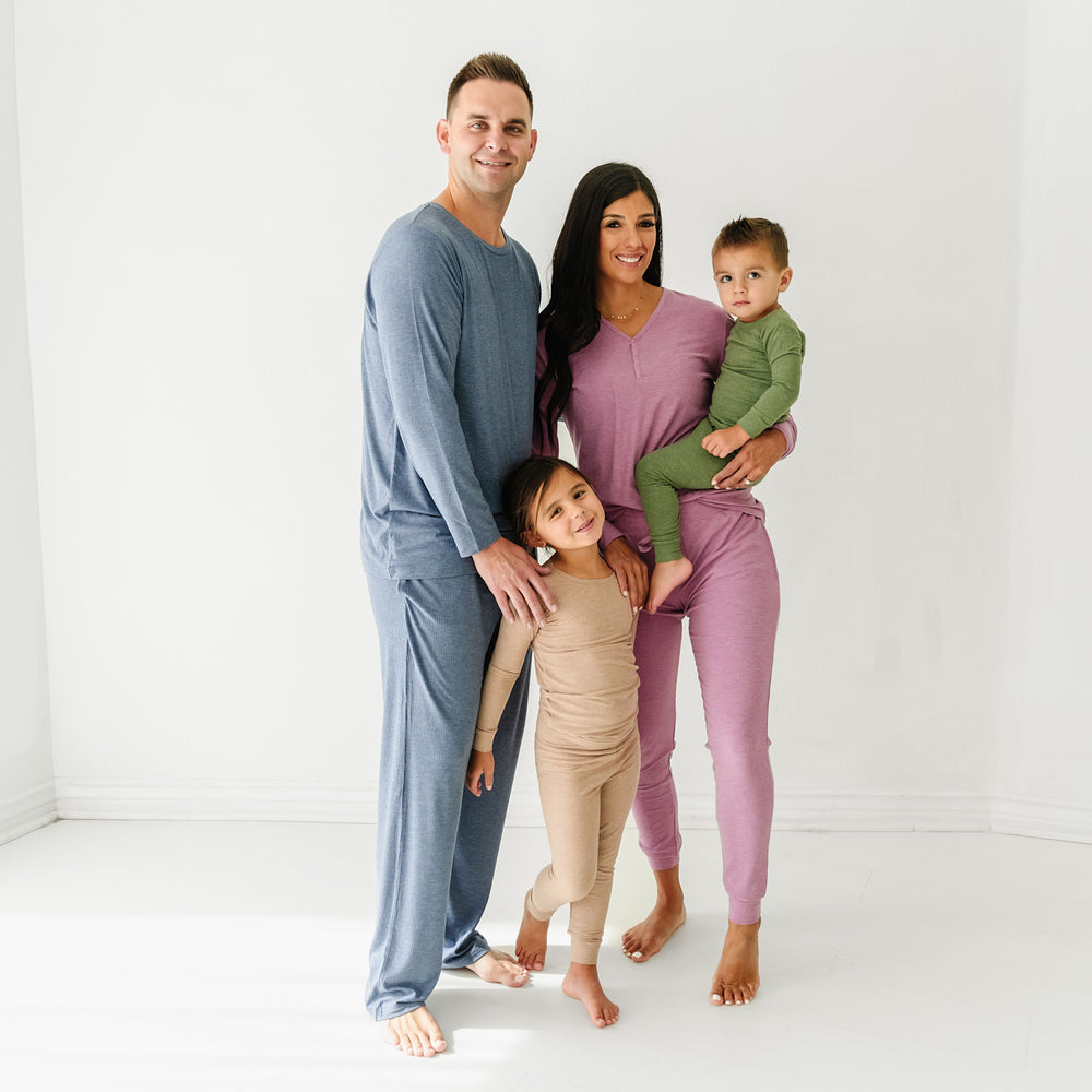 Family of four wearing coordinating Heather Ribbed pajamas. Dad is wearing Heather Dusty Indigo Ribbed men'a pajama top paired with men's pajama pants. Mom is wearing Heather Mulberry women's pj top paired with matching women's pj pants. Children are wearing Heather Fawn Ribbed and Heather Cypress Ribbed two piece pj sets
