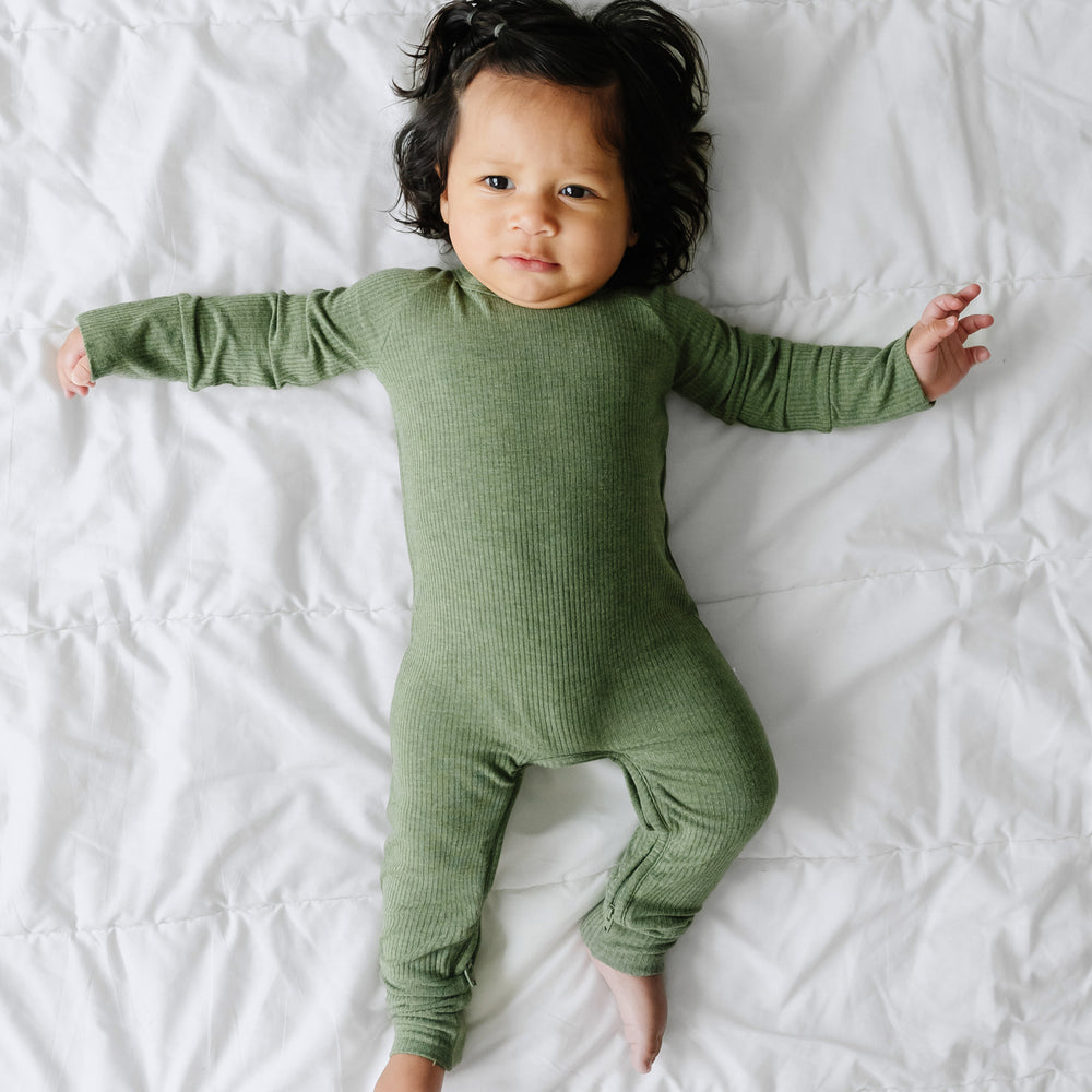 Alternate image of a child laying on a blanket wearing a Heather Cypress Green Ribbed crescent zippy