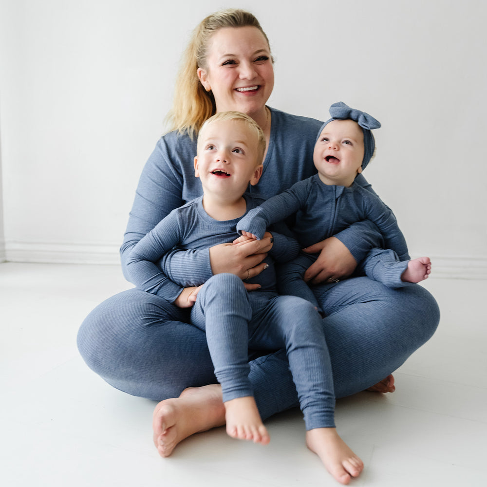 Mother and her two children wearing matching Heather Dusty Indigo Ribbed pajama sets paired with a matching luxe bow headband