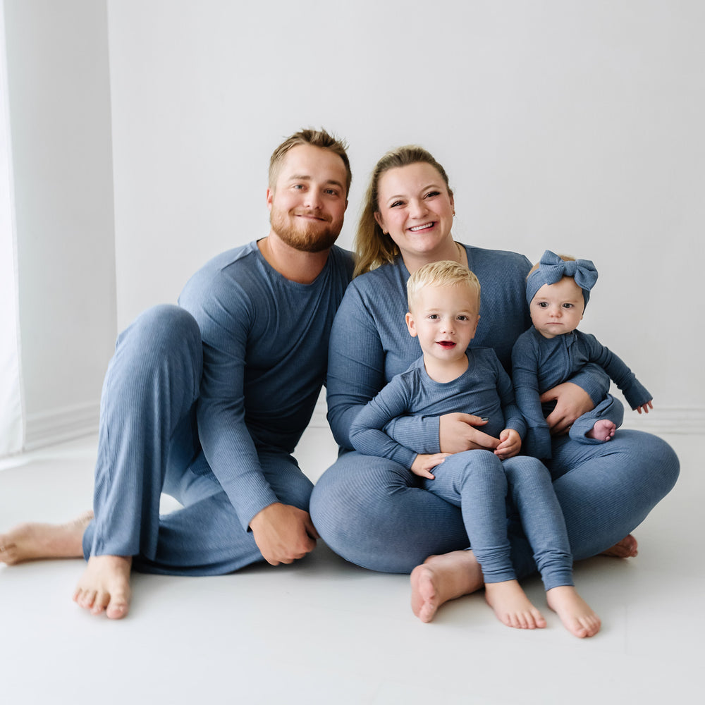 Family of four wearing matching Heather Dusty Indigo Ribbed pajama sets paired with a matching luxe bow headband