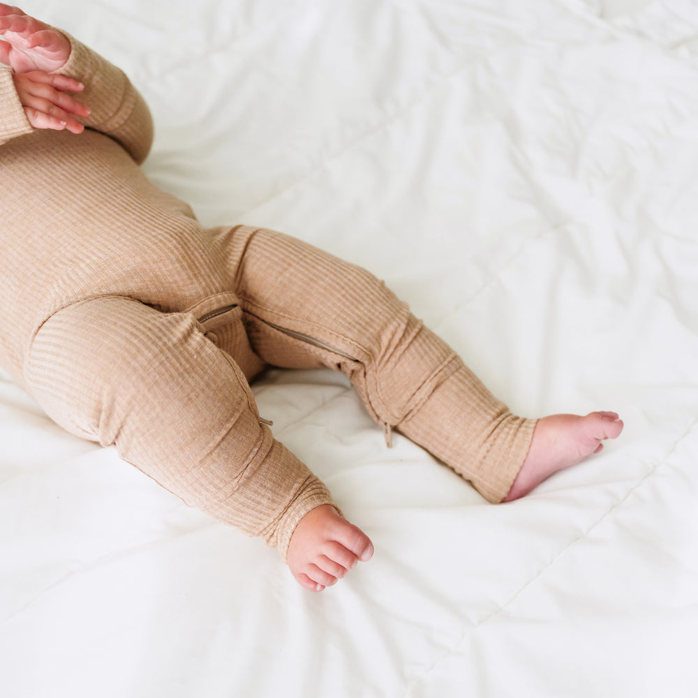 Close up image of a child's legs. Child is wearing a Heather Fawn Ribbed Crescent Zippy 