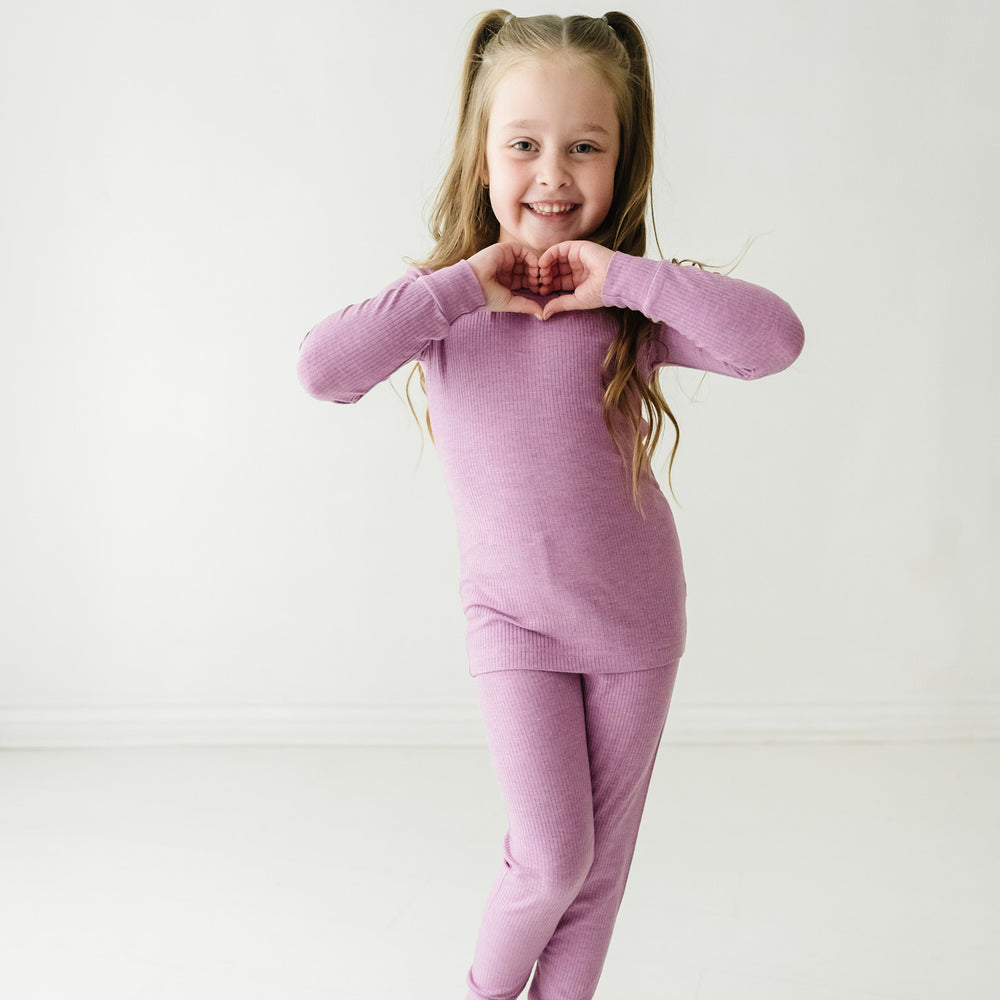 Child posing wearing a Heather Mulberry ribbed two piece pajama set