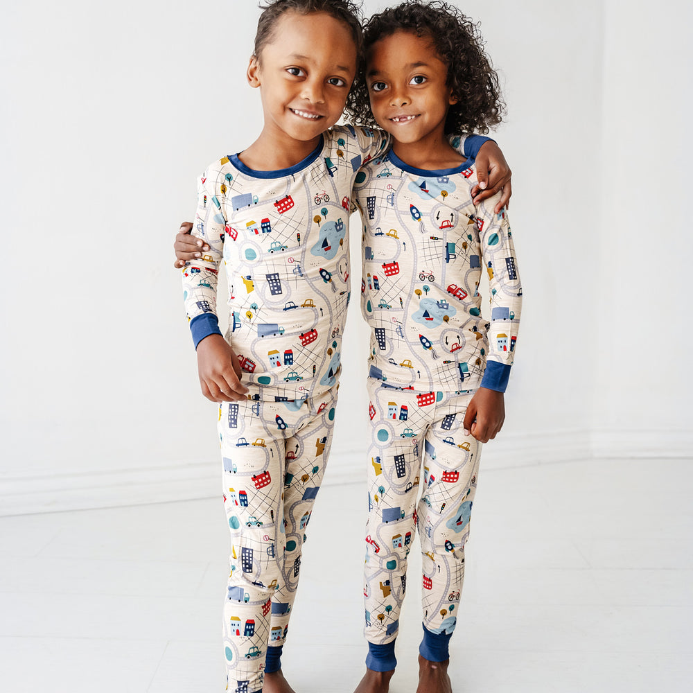 Click to see full screen - Two children embracing wearing Blue Road Trip two piece pajama sets