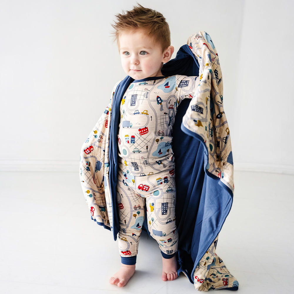 Click to see full screen - Alternate image of a child wearing a Blue Road Trip two piece pajama set holding up a matching large cloud blanket