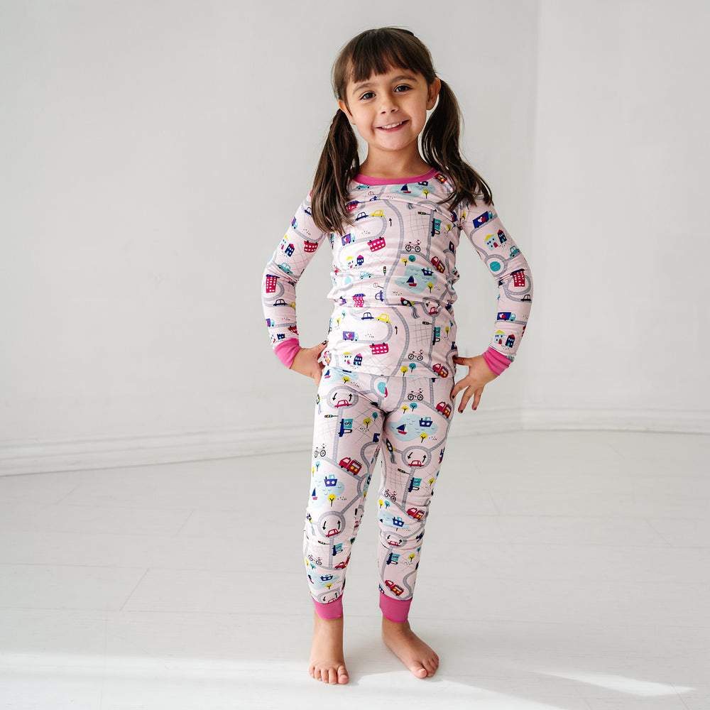 Click to see full screen - Child posing wearing a Rosy Road Trip two piece pajama set