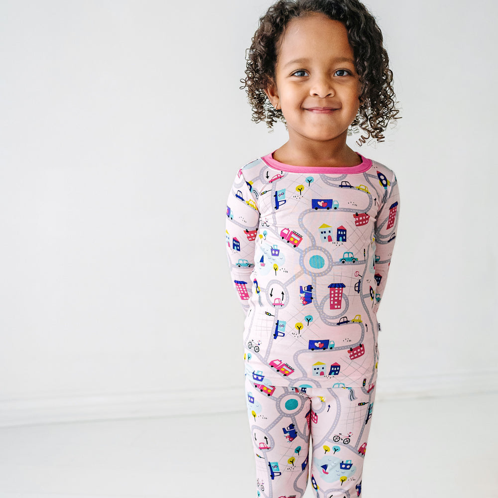 Click to see full screen - Close up image of a child wearing a Rosy Road Trip two piece pajama set