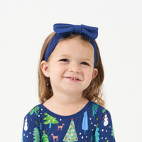 Alternate image of a child wearing a Sapphire luxe bow headband with a Blue Merry and Bright two piece pajama set