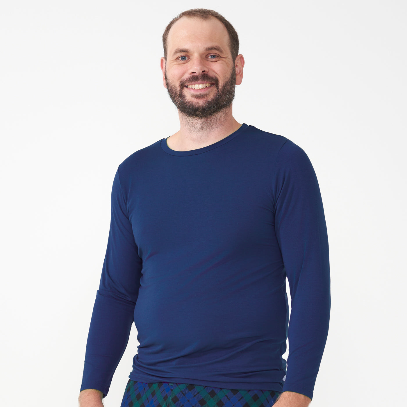 Man wearing a Sapphire men's pajama top paired with men's Emerald Plaid pajama pants