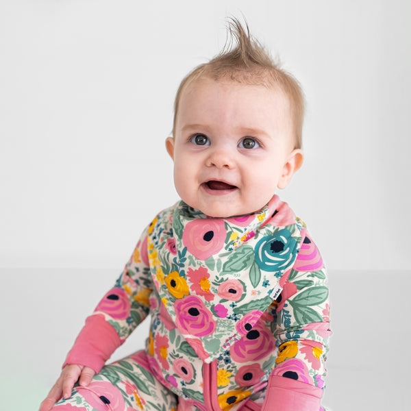 Close up of a child wearing a Secret Garden baby bandana bib and matching bamboo pajamas