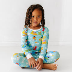 Child sitting on the ground wearing a Spelling with Sesame Street two-piece pajama set