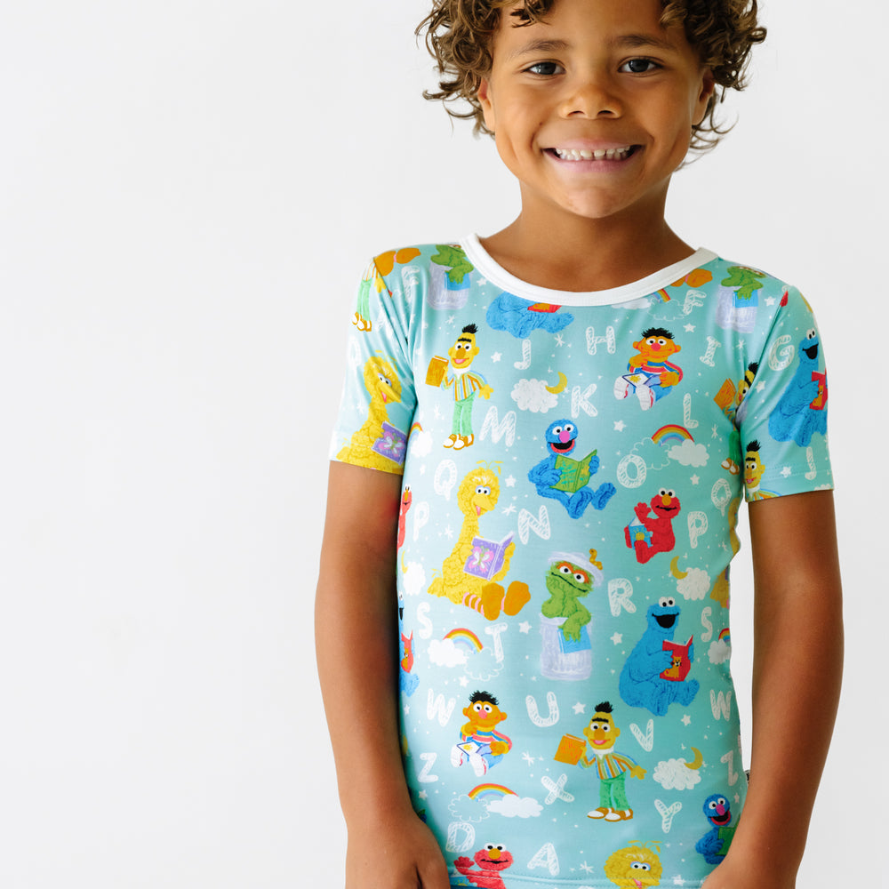 Close up image of a child wearing a Spelling with Sesame Street two piece short sleeve pajama set
