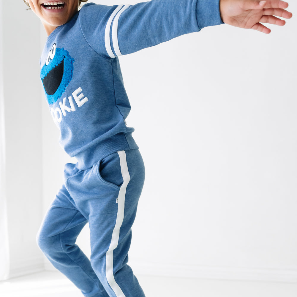 Side view image of a child wearing a Sesame Street Cookie Monster crewneck sweatshirt and jogger set
