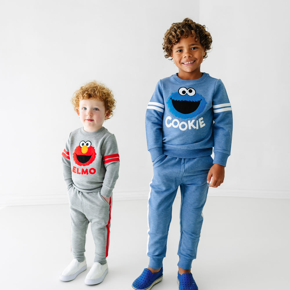 Two children wearing Sesame Street crewneck sweatshirt and jogger sets