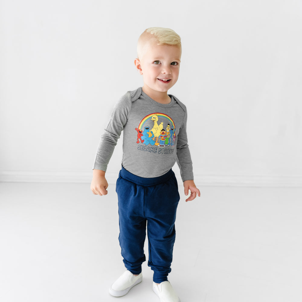 Child wearing a Spelling with Sesame Street gray graphic bodysuit and coordinating Classic Navy joggers