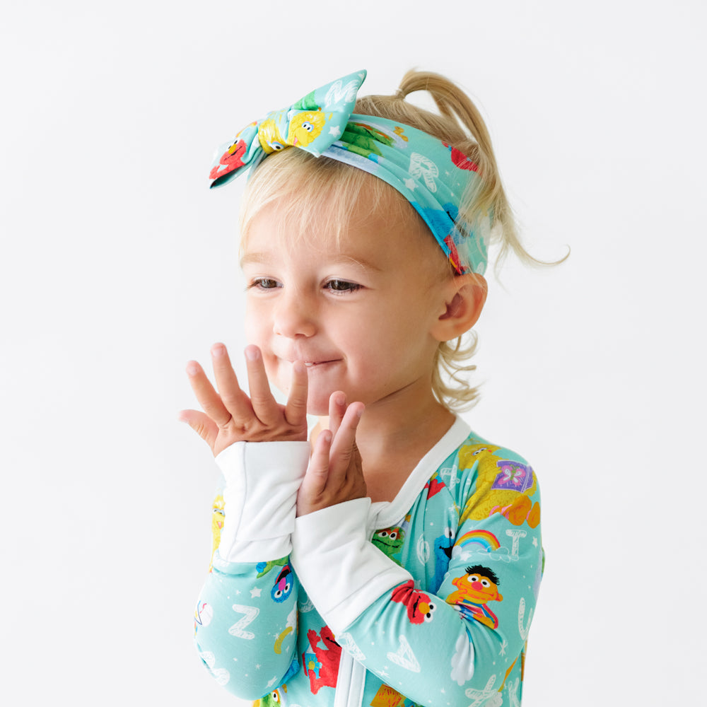Child wearing a Spelling with Sesame Street luxe bow headband