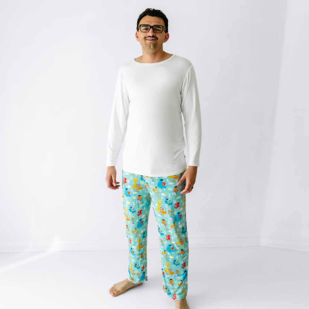 Man wearing Spelling with Sesame Street men's pajama pants and coordinating men's top