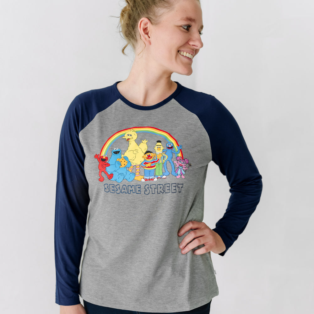 Woman wearing a Spelling with Sesame Street blue women's raglan tee