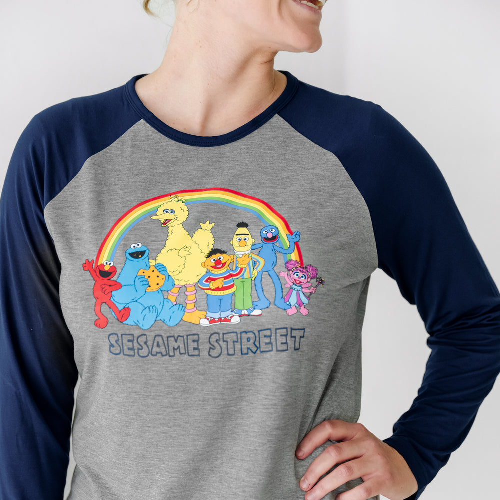 Close up image of a woman wearing a Spelling with Sesame Street blue women's raglan tee