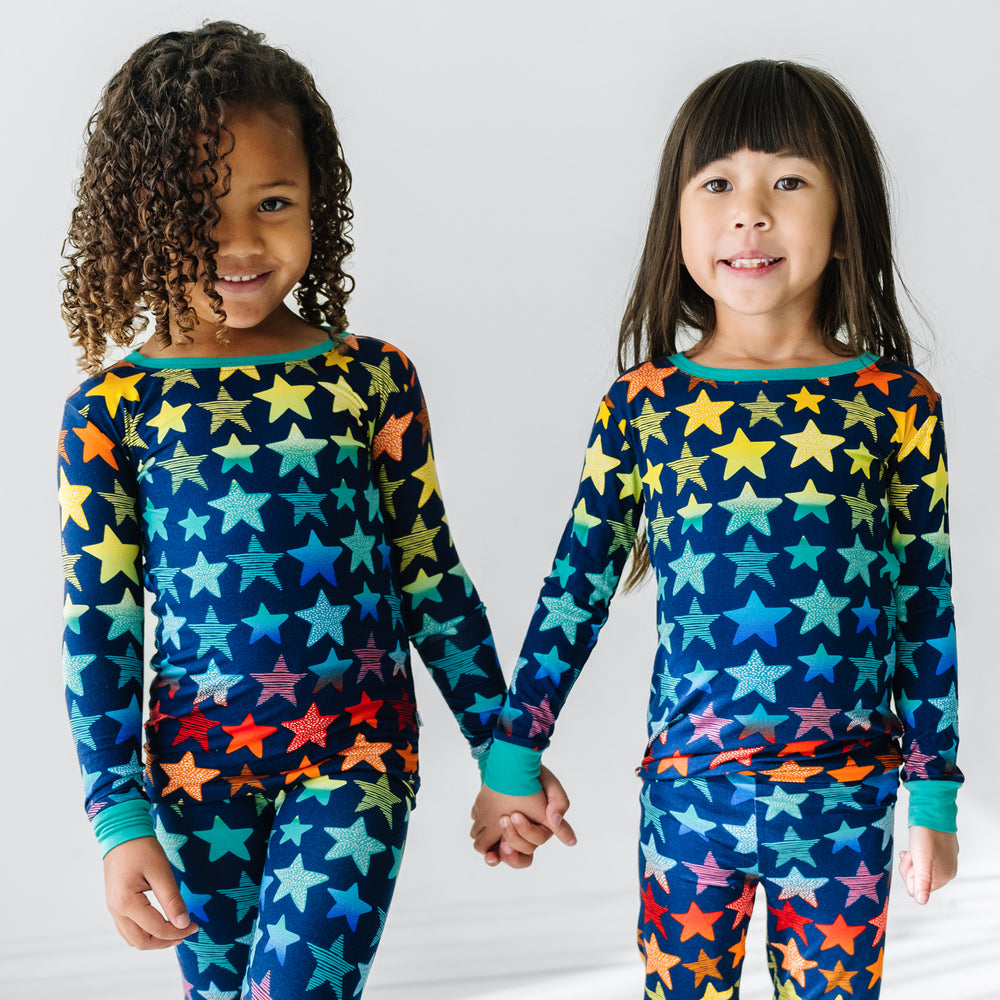 Click to see full screen - Two children holding hands wearing Shades of Stars two piece pajama sets