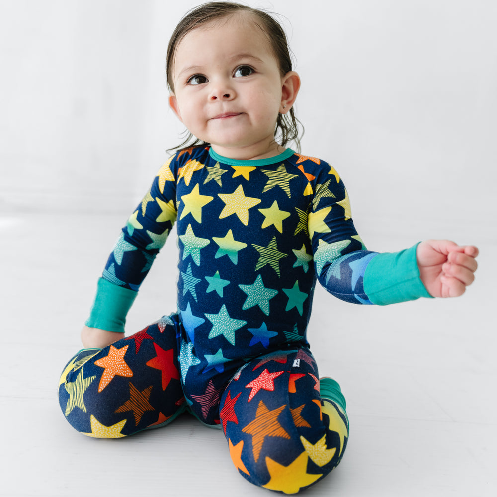 Click to see full screen - Child kneeling wearing a Shades of Stars crescent zippy