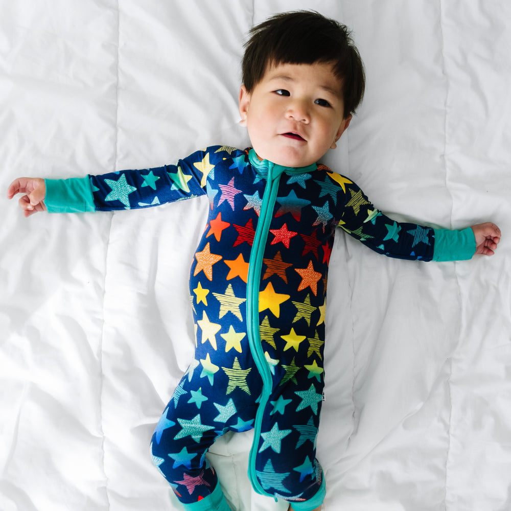 Click to see full screen - Child laying on a bed wearing a Shades of Stars zippy