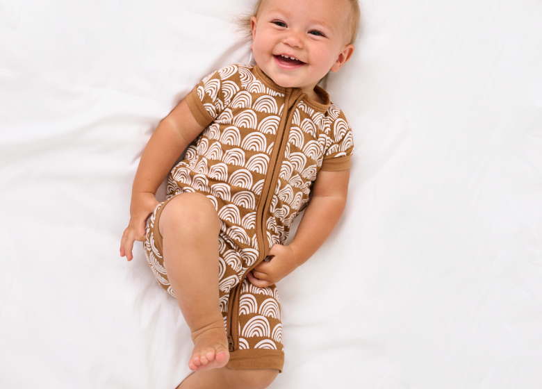Child laying down wearing a Rust Rainbows Shorty Zippy