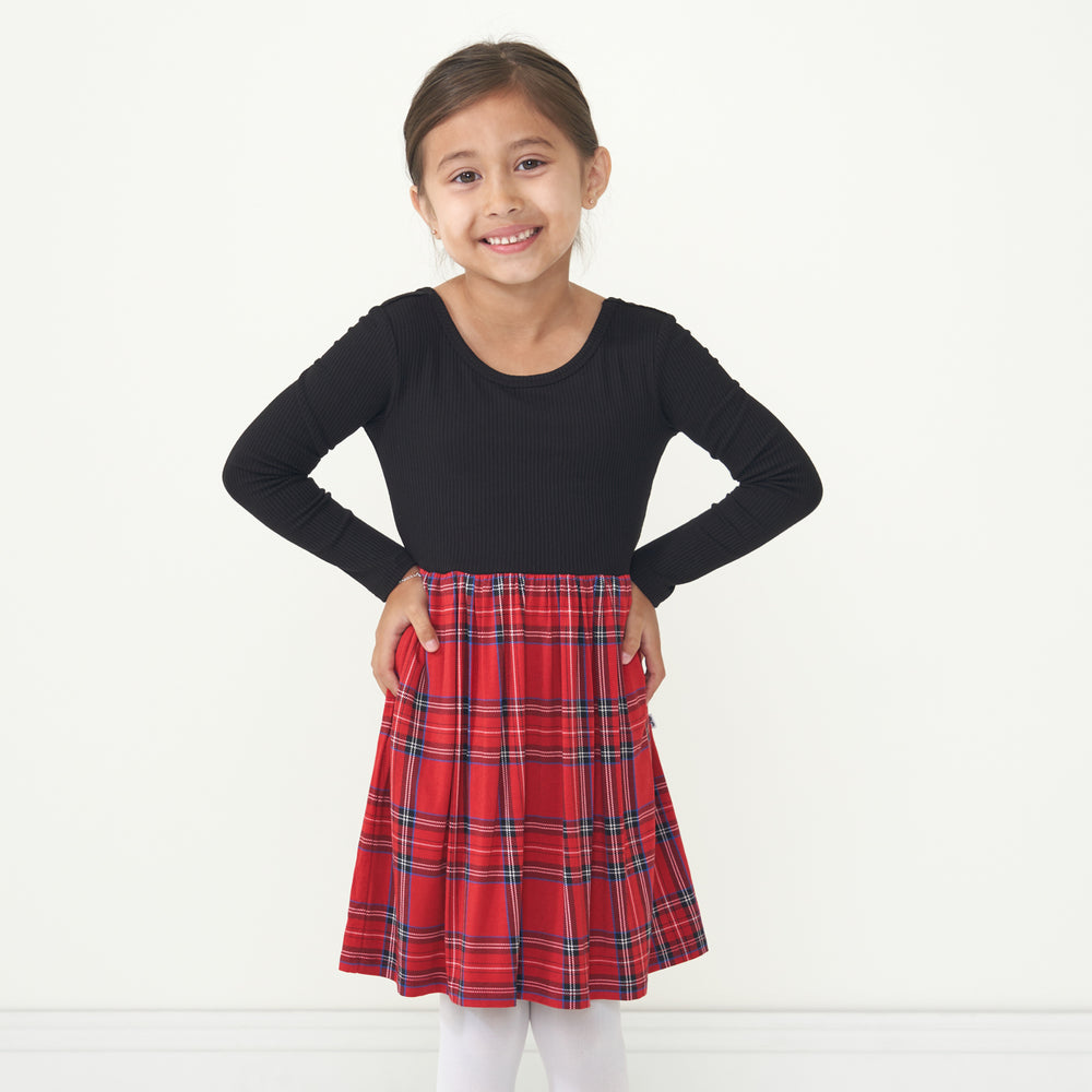 Child with her hands on her hips wearing a Holiday Plaid skater dress